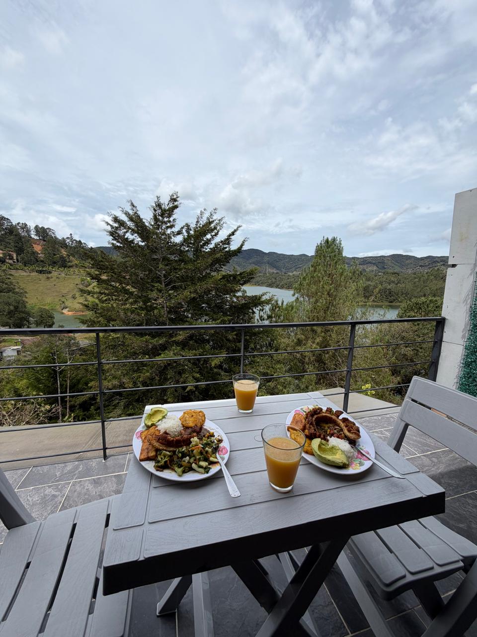 Deck privado con hamaca, sofá y mesa frente al embalse de Guatapé